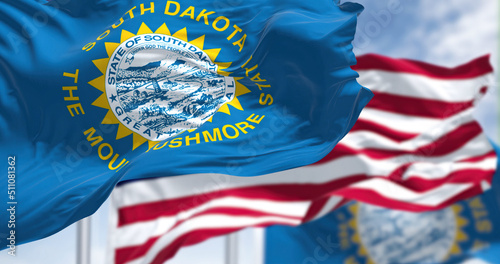 The South Dakota state flag waving along with the national flag of the United States of America