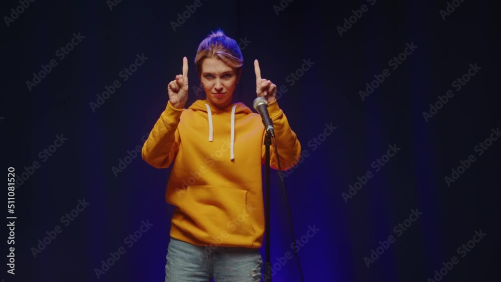 Talent contest. Woman showing funny magic tricks on stage, using hands. 