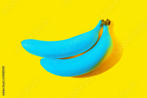 Fotografie Two ripe blue bananas cast a shadow isolated on a bright color yellow background