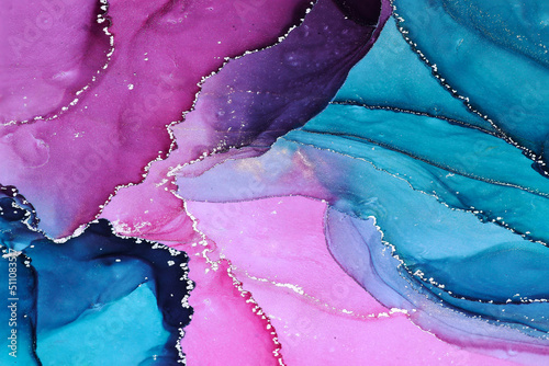 Abstract fluid ink painting background in pink blue colors with golden splashes.