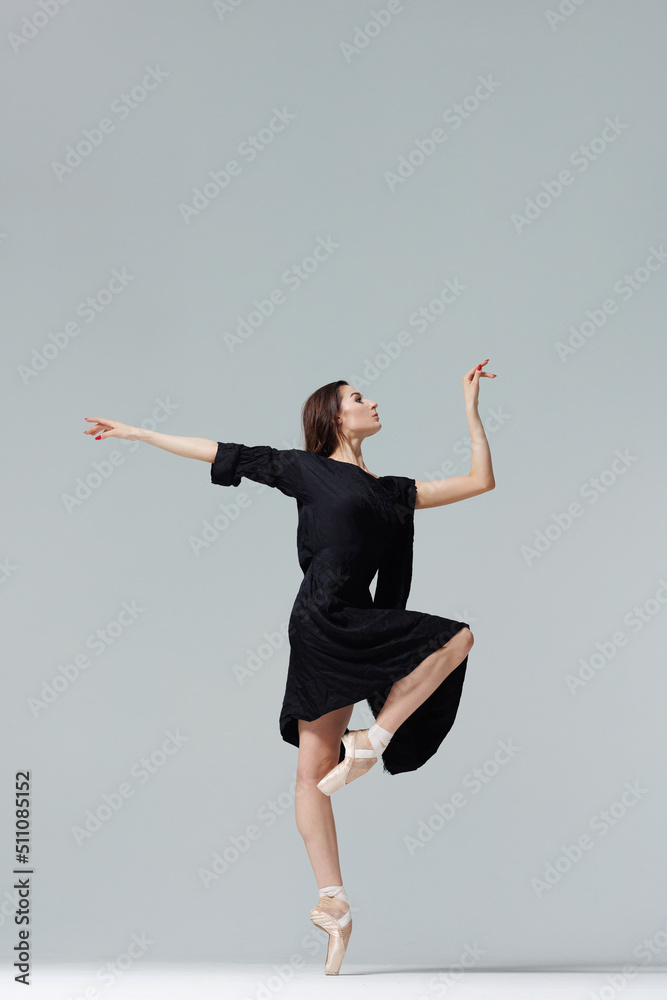 Elegant ballerina. A young graceful ballet dancer, dressed in pointes shoes demonstrates her dance skills. Power and refinement of classical ballet.