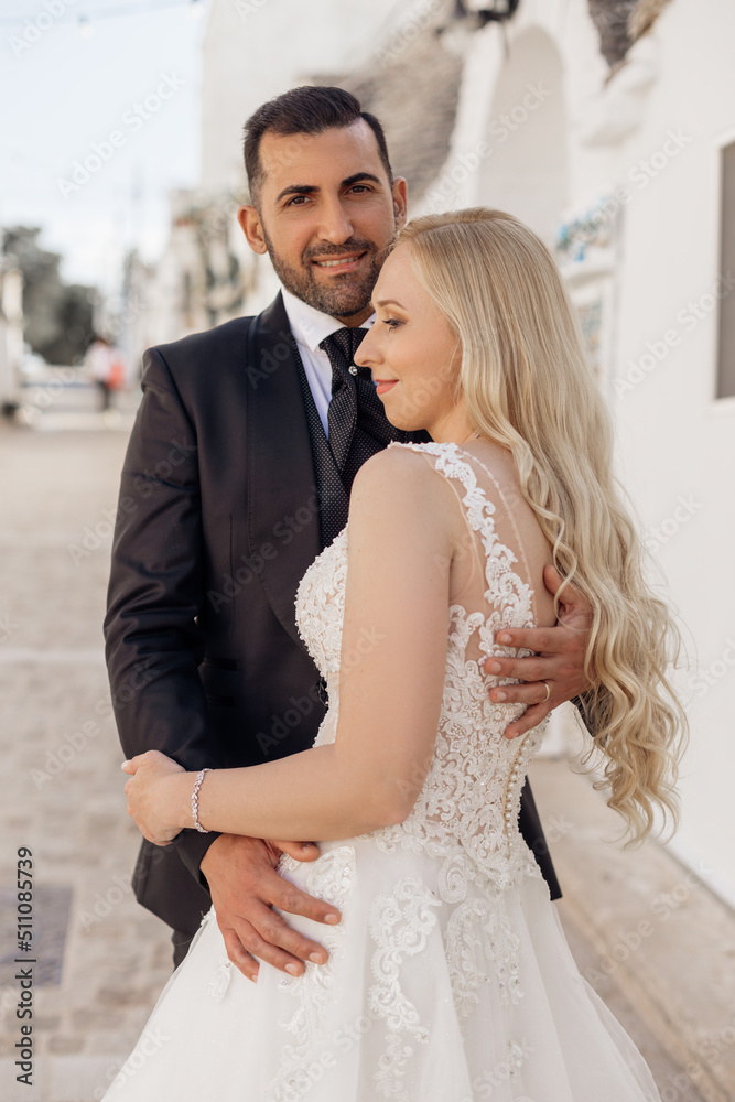 Naklejka premium Just married couple, pretty curly blond woman, bride and dark-haired bearded man, groom standing together. Newlyweds