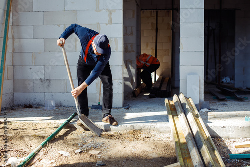 Φωτογραφία Worker builders, men in uniform and caps, labors, wetbacks preparing basement fl
