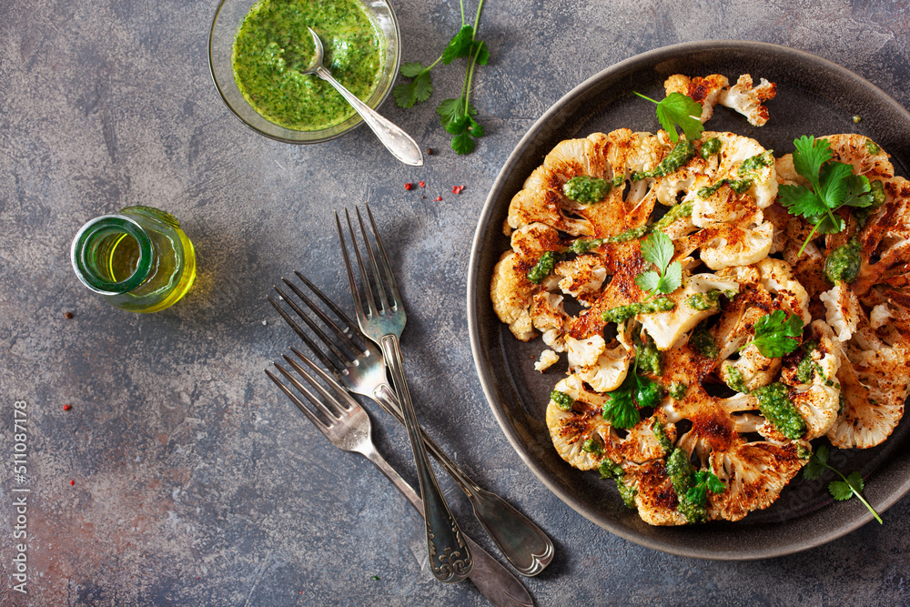 cauliflower steaks with herb sauce and spice. plant based meat substitute