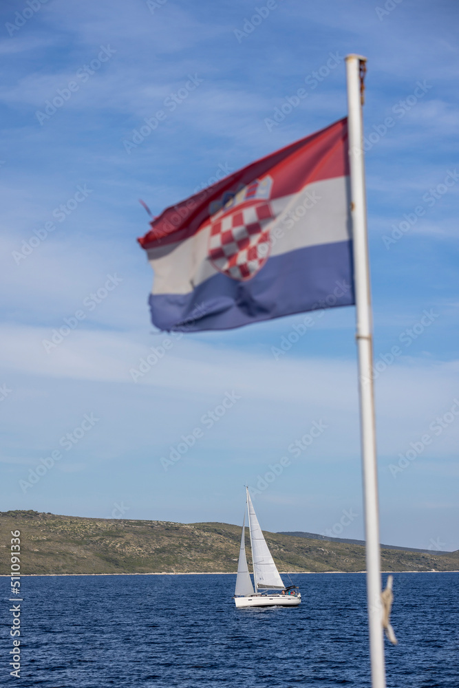croatian flag and sailboat in the mediterranean sea
