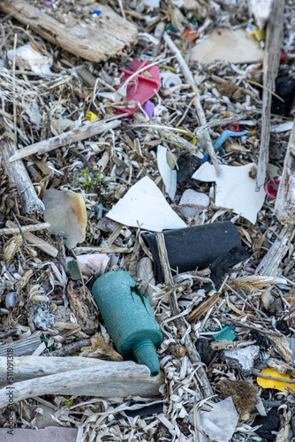 Plastic bottles and waste washed up on a beach by the incoming tide, covering the entire beach 