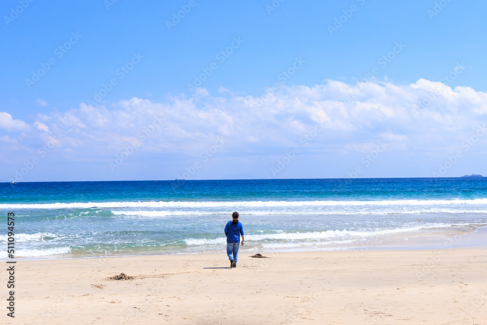 南伊豆の美しい吉佐美大浜の砂浜を歩く女性