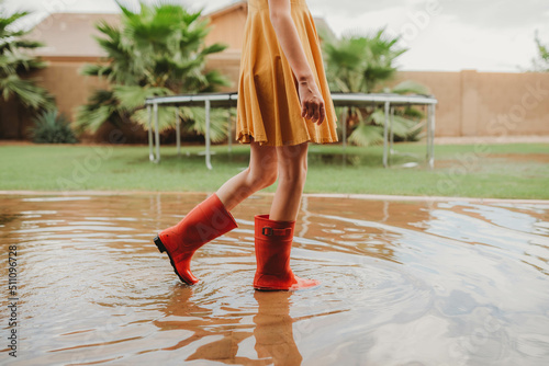 Girl walking in rainboot in eater puddle photo