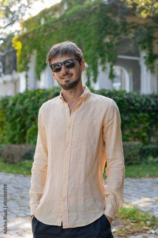 A European-looking man wearing an orange shirt and sunglasses. A tropical country in the hot summer. A European-looking man wearing an orange shirt and sunglasses. A tropical country in the hot summer.