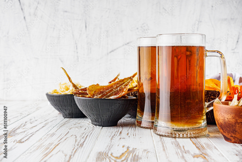 mug of beer and a set of dry fish snacks on a white wooden rustic background mug of beer and a set of dry fish snacks on a white wooden rustic background