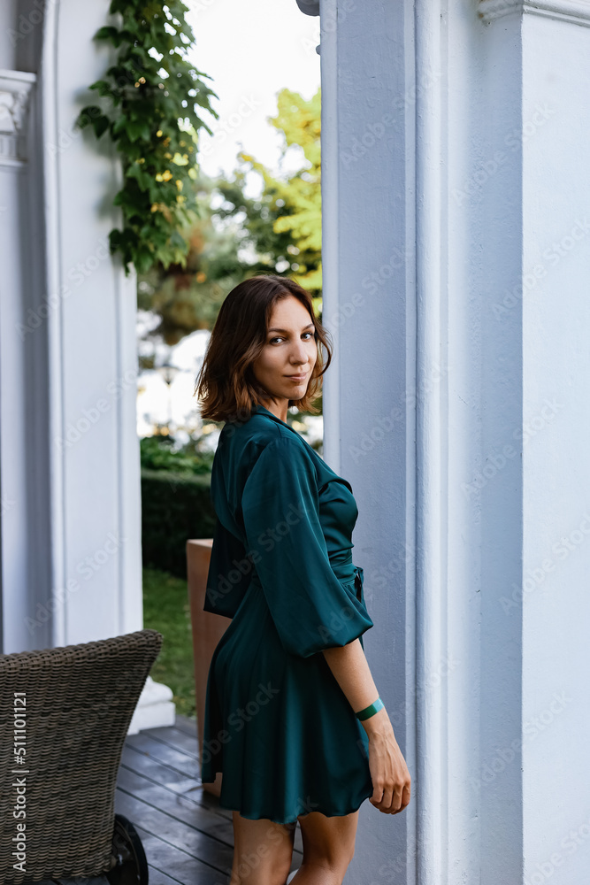 A smiling, sophisticated girl in a turquoise light dress walks in a well-kept green park. It's a hot summer in a tropical country. A smiling, sophisticated girl in a turquoise light dress walks in a well-kept green park. It's a hot summer in a tropical country.