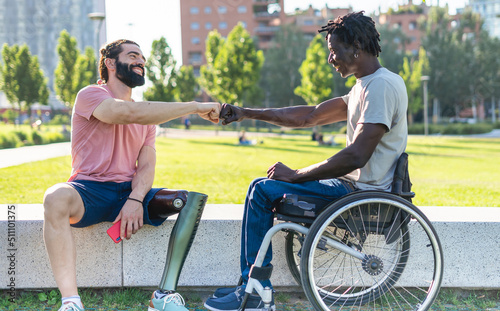 Two disabled friends give fist bump as a sign of friendship  and determination photo