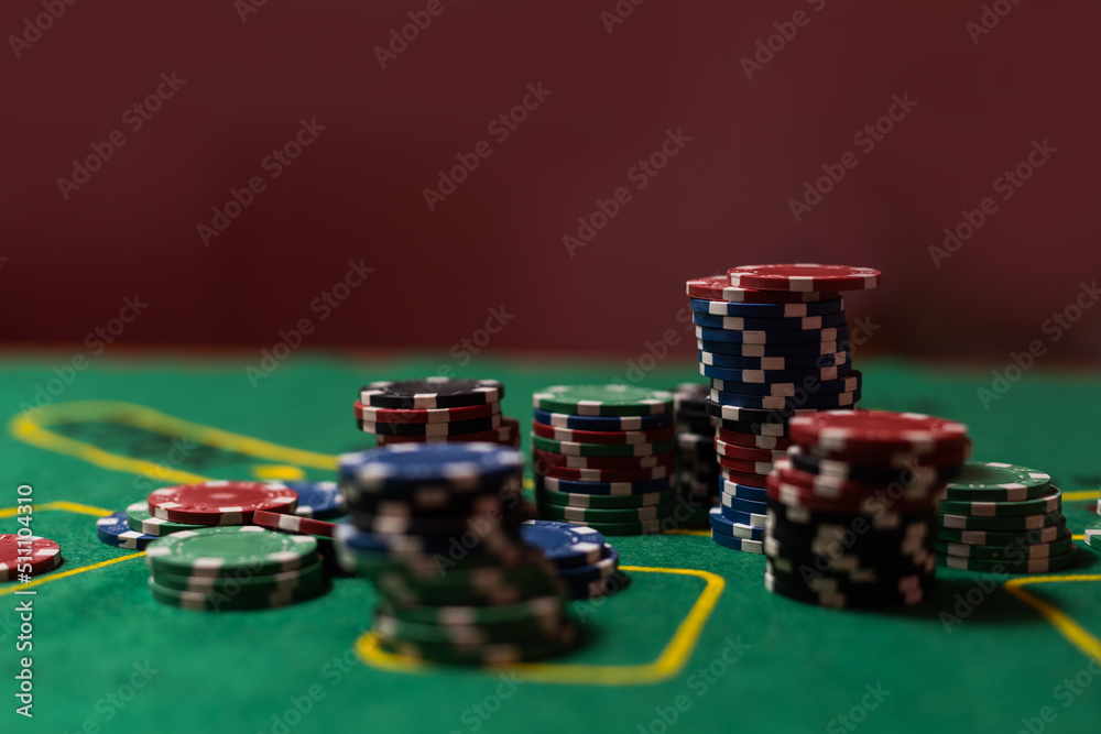 gambling, fortune, game and entertainment concept - close up of casino chips on green table surface gambling, fortune, game and entertainment concept - close up of casino chips on green table surface