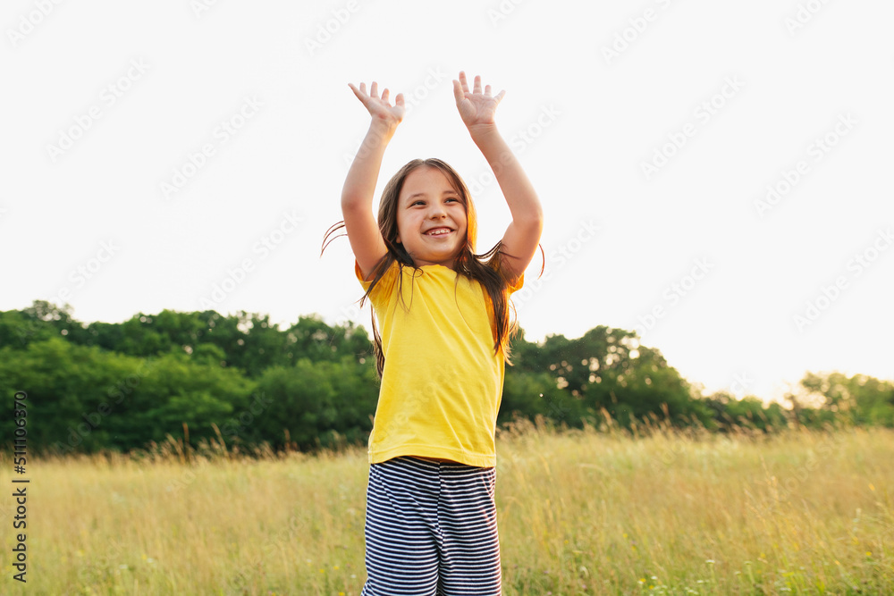 Happy little girl in the green meadow on a sunny summer day, child happiness Happy little girl in the green meadow on a sunny summer day, child happiness