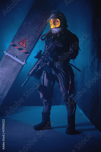 Spaceman or star trooper in the helmet and with rifle in the blue smoke. Science fiction concept.