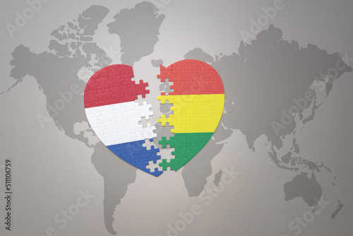 puzzle heart with the national flag of bolivia and netherlands on a world map background.Concept.
