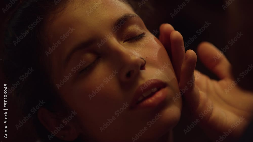 Closeup woman enjoy sensual touch on date. Man hand caress face cheek at evening