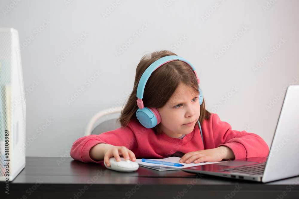 Home schooling. Girl at the computer in headphones. Home schooling. Girl at the computer in headphones.