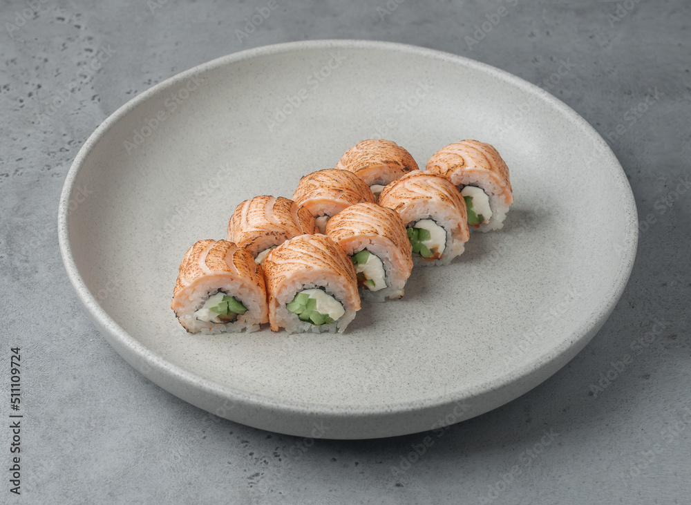 maki sushi with burnt salmon on gray background