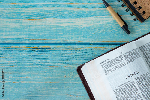 1 Kings open Holy Bible Book on a rustic wooden background with copy space. Top table view. Old Testament Scripture study, Christian biblical concept.	 photo