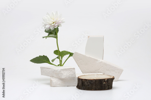 Stones, wood platform podium and flower on gray light copy spase background. Minimal empty display product presentation scene.
