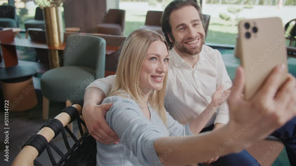 Happy family couples talking on video using mobile phone calling from cafe. Chatting online by web camera. Sitting in cafe. Slow motion Happy family couples talking on video using mobile phone calling from cafe. Chatting online by web camera. Sitting in cafe. Slow motion