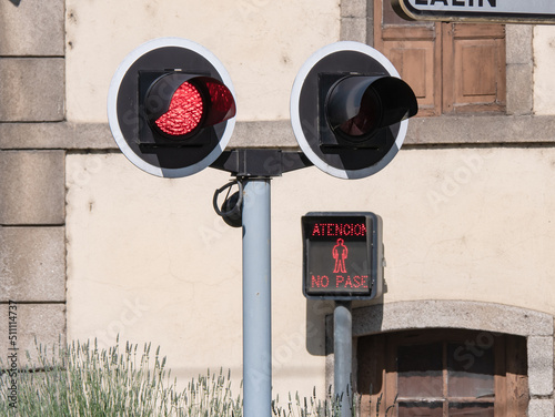 Warning lights for pedestrians and vehicle drivers lit at a level crossing due to the proximity of a train and the danger to citizens and the obligation to stop