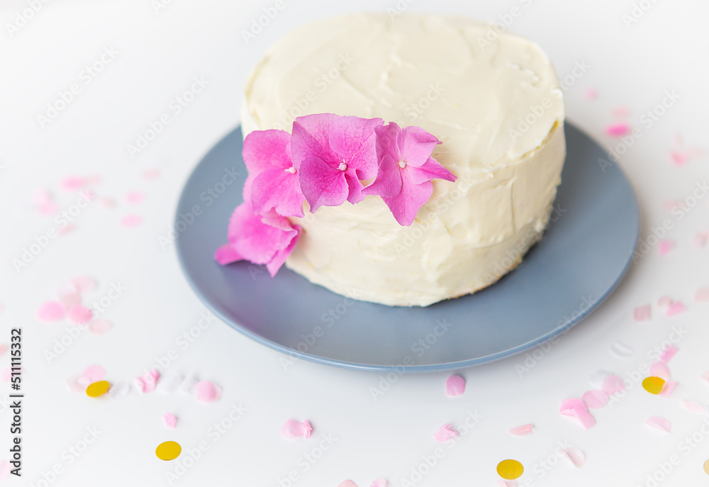 Very beautiful small white bento cake, decorated with fresh flowers of pink hydrangeas. Holiday and fun concept. Very beautiful small white bento cake, decorated with fresh flowers of pink hydrangeas. Holiday and fun concept.