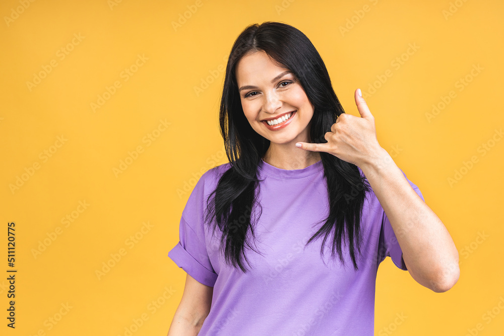 Call me baby! Portrait of happy smiling brunette girl in casual isolated over yellow background. Call me baby! Portrait of happy smiling brunette girl in casual isolated over yellow background.