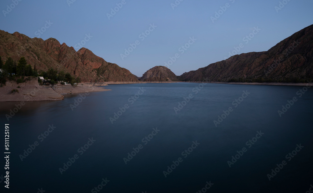 Night shot. View of the lake and mountains at nightfall. Beautiful blurred water effect and color.