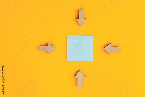 Colorful sticky notes and different wooden arrows on yellow background. © ALEXSTUDIO