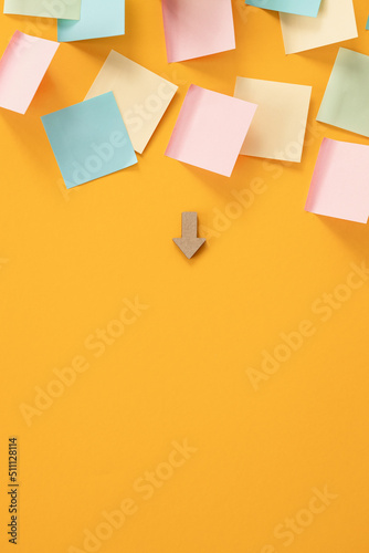 Blank colorful sticky notes and wooden arrows on yellow background, flat lay.