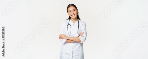 Asian female doctor, physician in medical uniform with stethoscope, cross arms on chest, smiling and looking like professional, white background