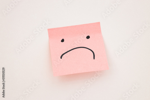 sad face on post it note on white background