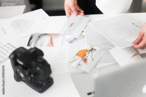 Woman sorting through photos in office (ID: 511133574)