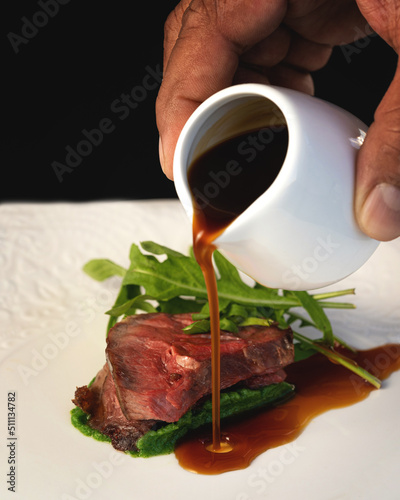 Εκτύπωση καμβά half-cooked lamb meat with arugula and hand pouring gravy