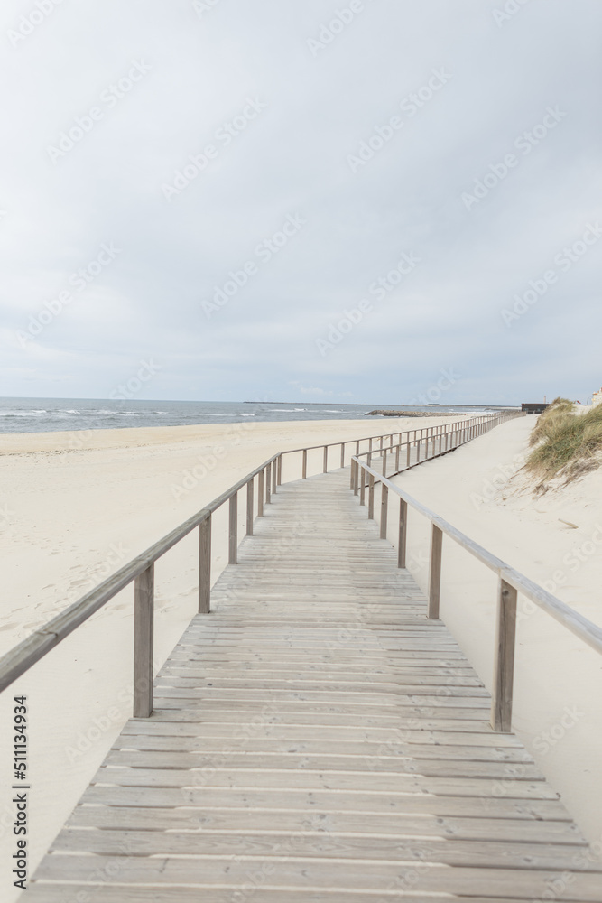 Beautiful sandy beach with a wooden walkway by the sea