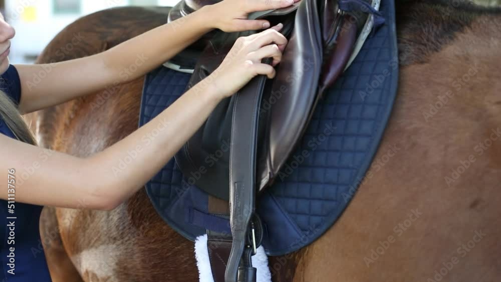 Person adjusting stirrup leather on an English saddle