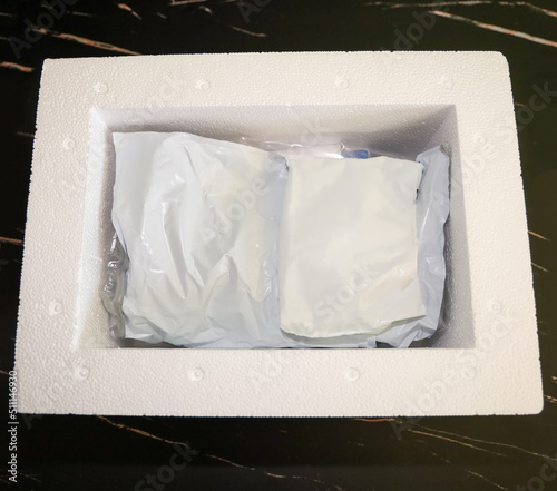 View of the inside of package received by mail with medication that needs refrigeration packed with gel refrigerant in a Styrofoam cooler.