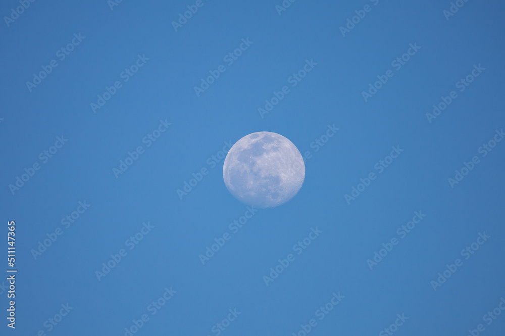 A full moon during the day on the blue sky, San Diego, California.