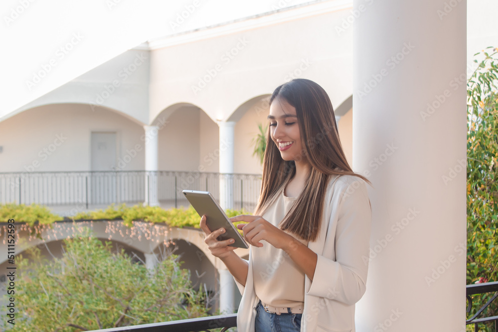 enterprising young woman using tablet on hotel balcony.