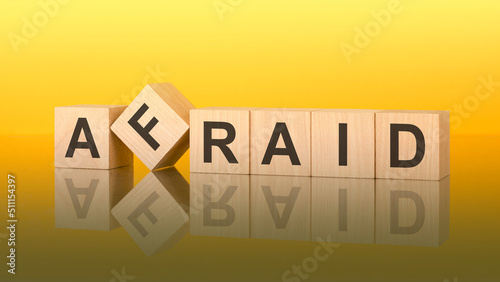 Fotografie afraid word is made of wooden blocks lying on the yellow table, concept
