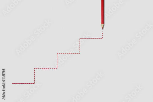 A red pencil draws the stairs on a gray background. Business, education or career concept - achievement of success.