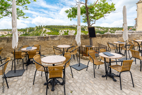 An outdoor cafe overlooking the Alpilles mountains and the valley of Les Baux in Les Baux-de-Provence, in the Provence region of Southern France фототапет