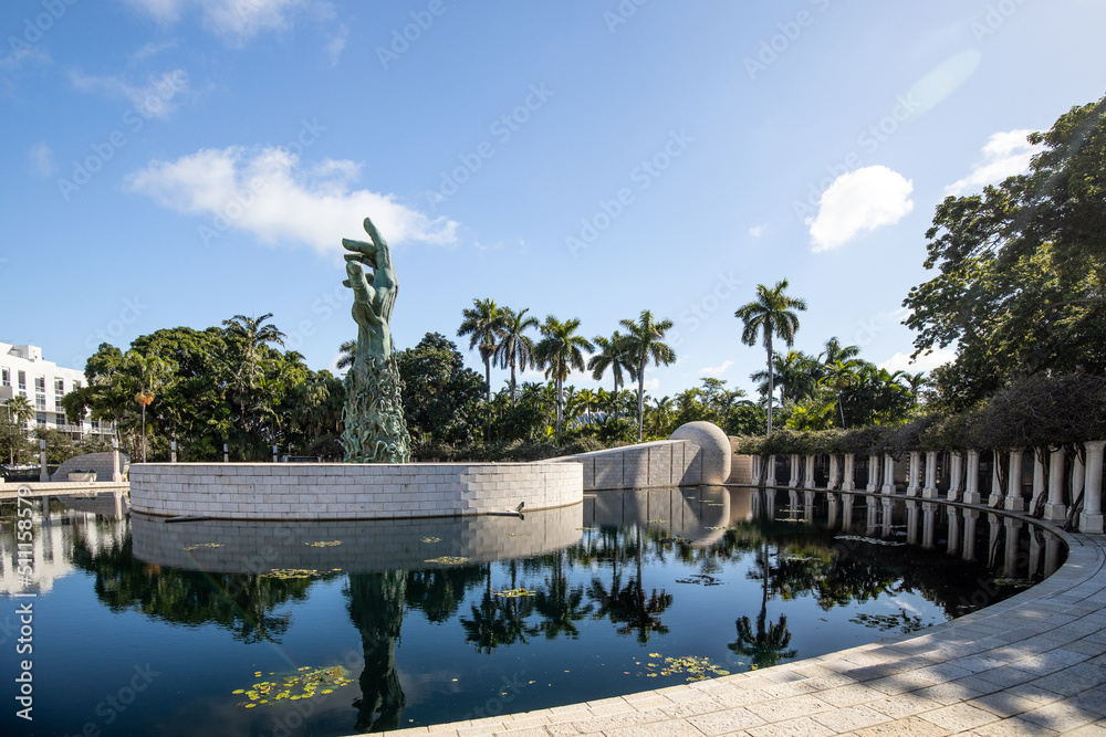 MIAMI BEACH, FL, USA - OCTOBER 14, 2019: The Holocaust Memorial in Miami Beach features a reflection pool with a hand reaching up and bodies climbing,  a memorial wall, and memorial bridge.