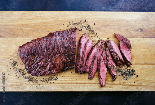 Traditional American barbecue bavette steak with salt and pepper served as top view on a modern design wooden board photo