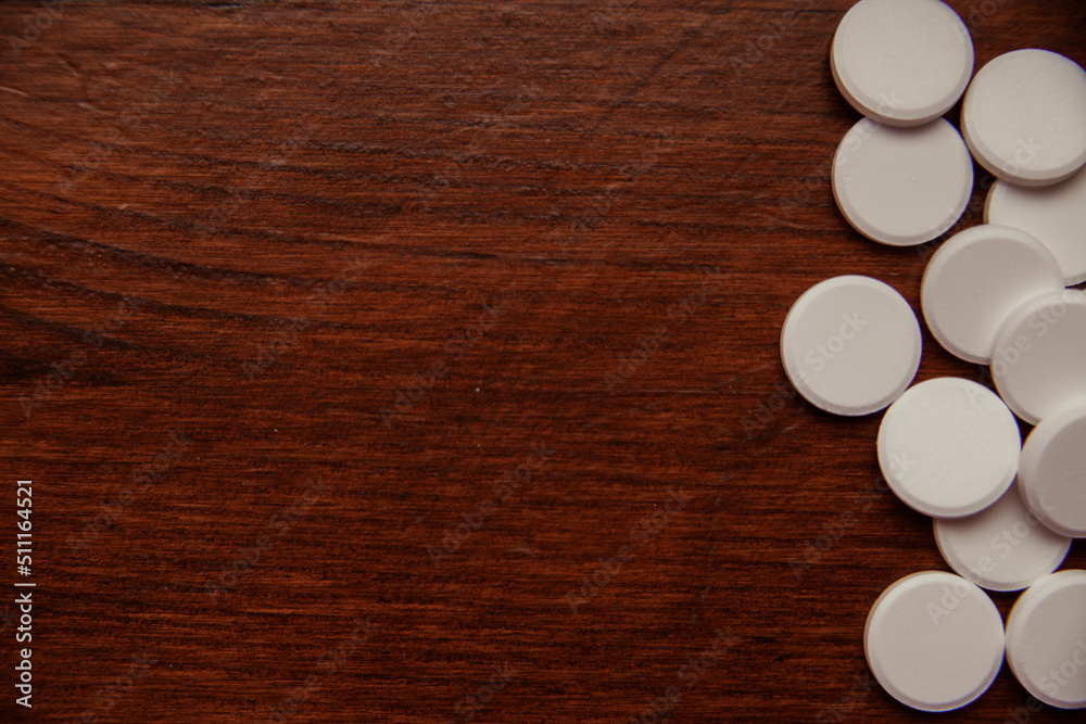 Pills on the table top view. Medicine background for design. The pills lie on a wooden table. Narcotic substances. Pills on the table top view. Medicine background for design. The pills lie on a wooden table. Narcotic substances.