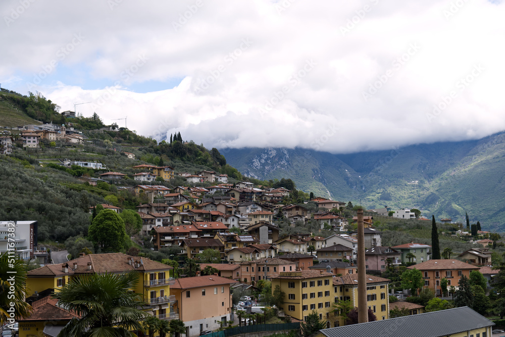 Italy: panorama of a village on Lake Garda with the peaks of the Alps covered by clouds