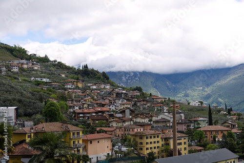 Italy: panorama of a village on Lake Garda with the peaks of the Alps covered by clouds