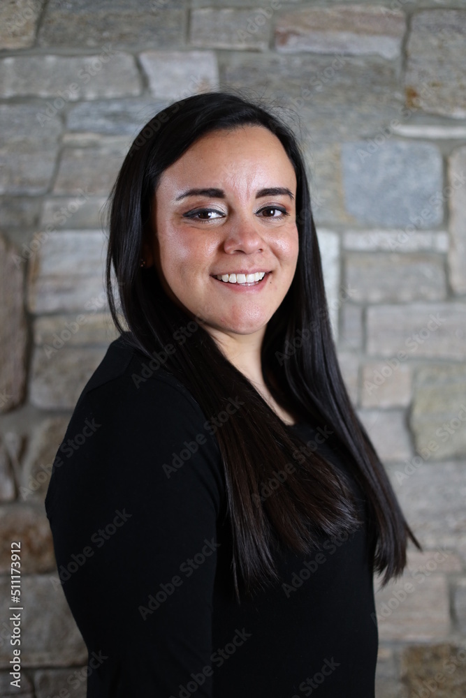 woman in black standing in front of stone wall